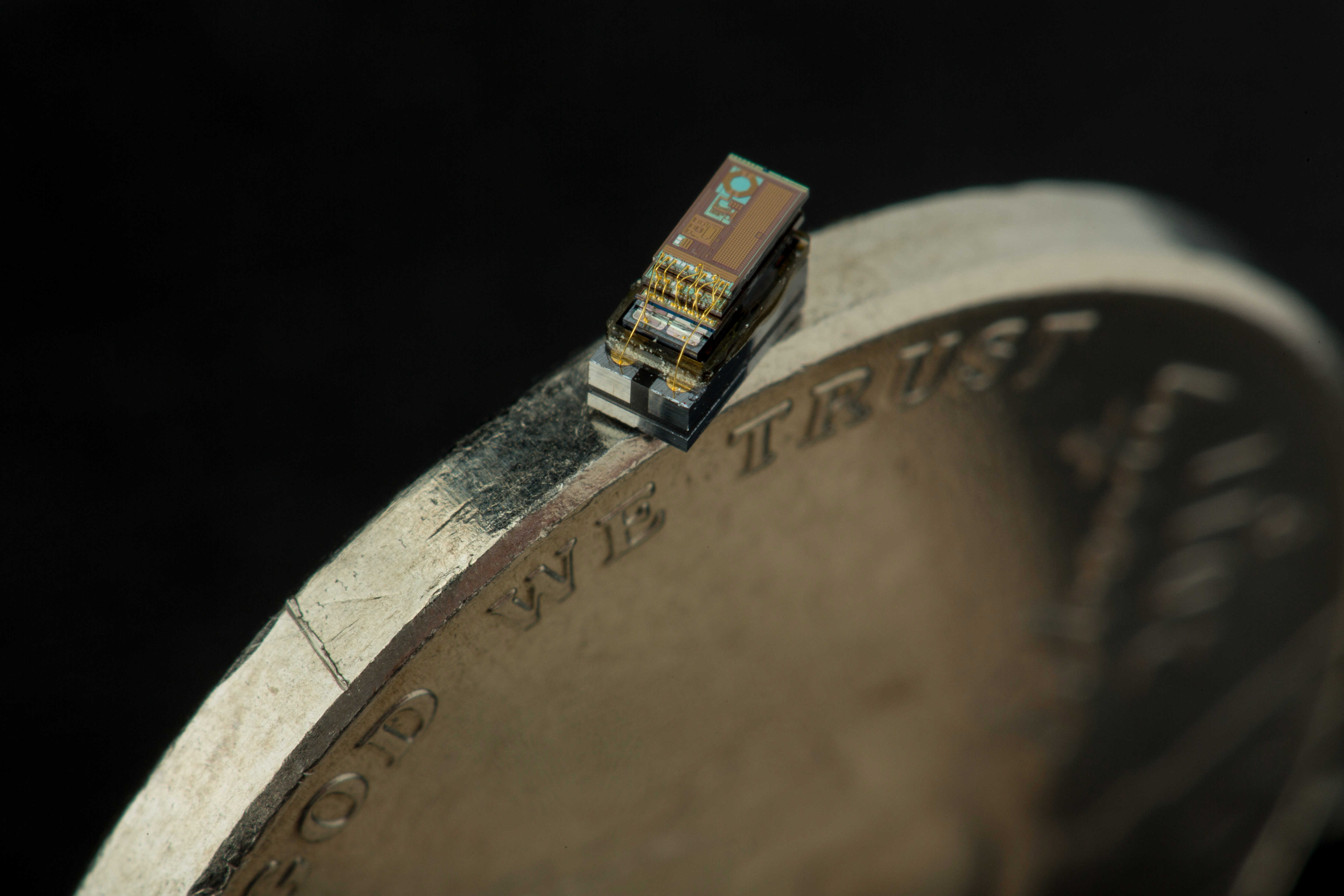 microcomputer balanced on the rim of a nickle